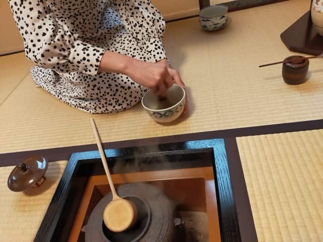 茶道体験の様子。炭で沸かしたお湯を使い、初心者が抹茶を点てる場面