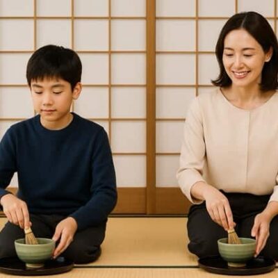和室の畳に正座し、母と息子が並んで茶筅を使い抹茶を点てている様子。