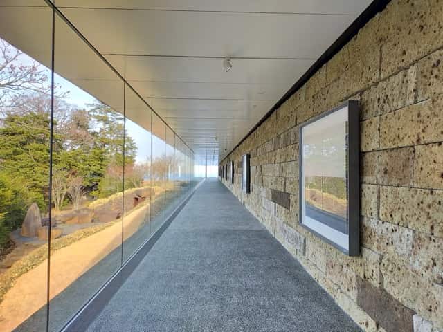 江之浦測候所のギャラリー棟に続くガラス回廊。光と影が美しく交差する空間。
