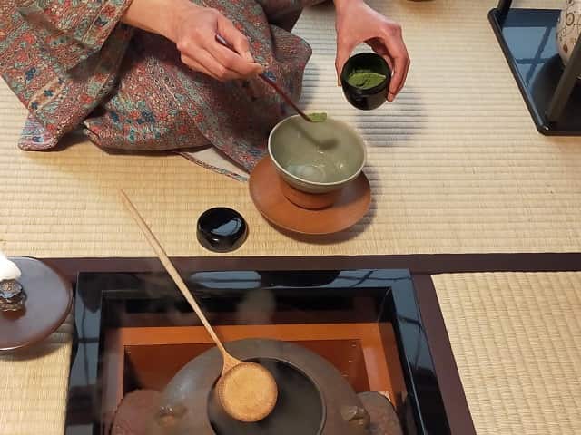 茶道教室で、天目茶碗の湯に抹茶を一勺入れるお茶湯の手元。点てずに供える表千家の作法。